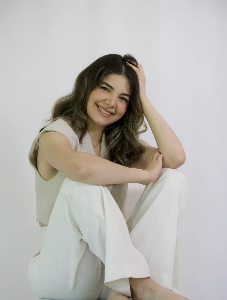 Delara, the founder, smiling quietly in a serene portrait